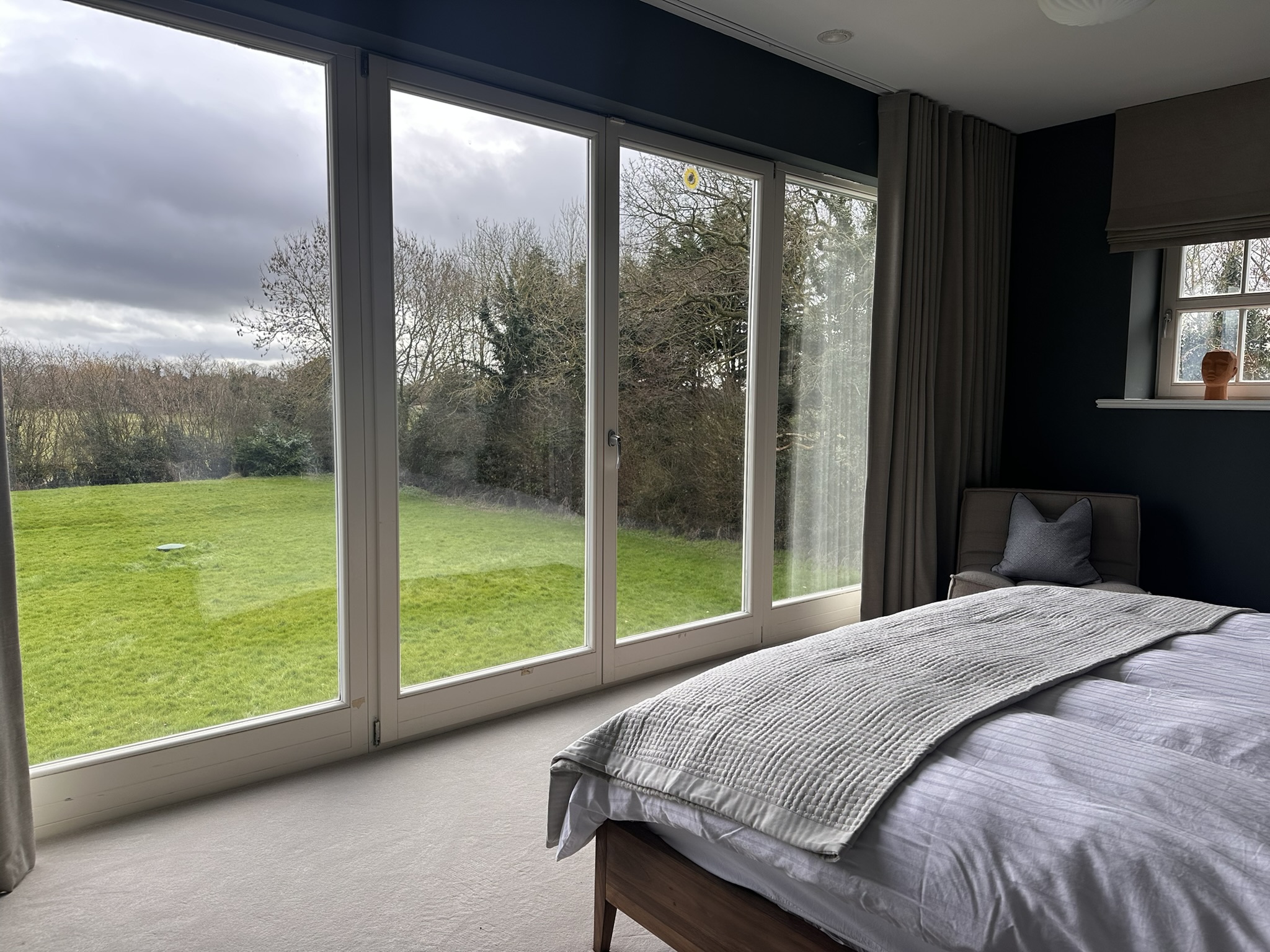 The master bedroom with king bed and floor-to-ceiling windows